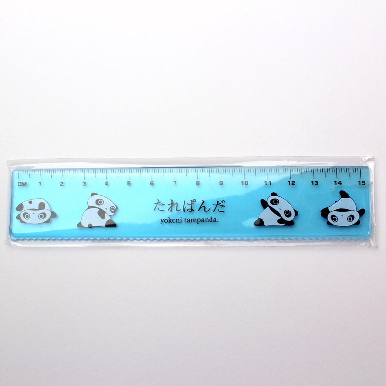 Puede incluir: Una regla de pl&aacute;stico azul con un dise&ntilde;o de oso panda. La regla mide hasta 15 cent&iacute;metros y tiene el texto "Tarepanda" en japon&eacute;s.
