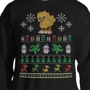 Pode incluir: Camisola de Natal preta com um design pixelado de um pintinho amarelo, árvores de Natal e presentes. A camisola tem um padrão de floco de neve.