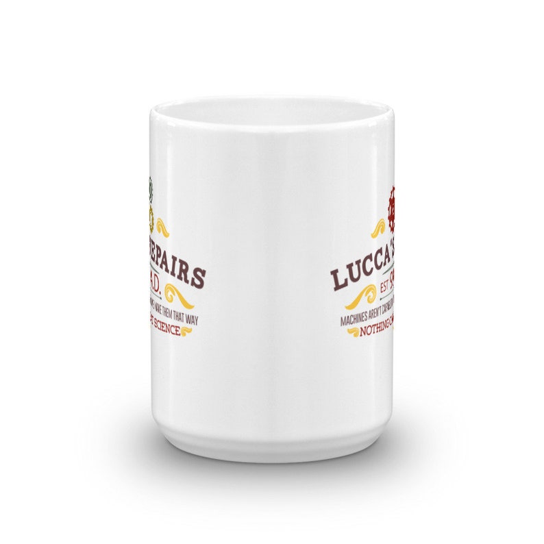 May include: White ceramic mug with the text "Lucca's Repairs" in brown and gold lettering. The mug has a cylindrical shape and a handle. The text includes the phrase "Machines aren't magic, nothing is".