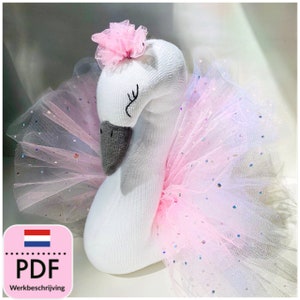 Pode incluir: Um cisne branco de meia com um tutu de tule rosa e uma flor rosa na cabeça. O cisne é um projeto artesanal feito à mão.
