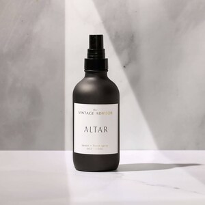 May include: A black glass bottle with a black spray nozzle. The bottle is labeled "The Vintage Advisor" and "Altar" with the text "space + linen spray 60 ml (2 fl oz)".