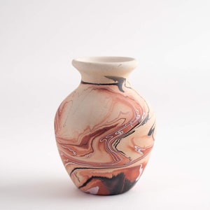 May include: A small, hand-painted ceramic vase with a marbled design in shades of brown, orange, white, and black.