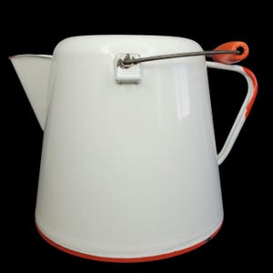 Może przedstawiać: Biały dzbanek emaliowany z pomarańczowym uchwytem i pokrywką z drutu. Dzbanek ma szeroką podstawę i wąski dzióbek.