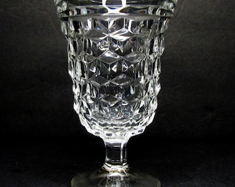 Peut inclure: Un gobelet en verre transparent avec un motif en diamant. Le gobelet a une base large et une tige haute et fine.