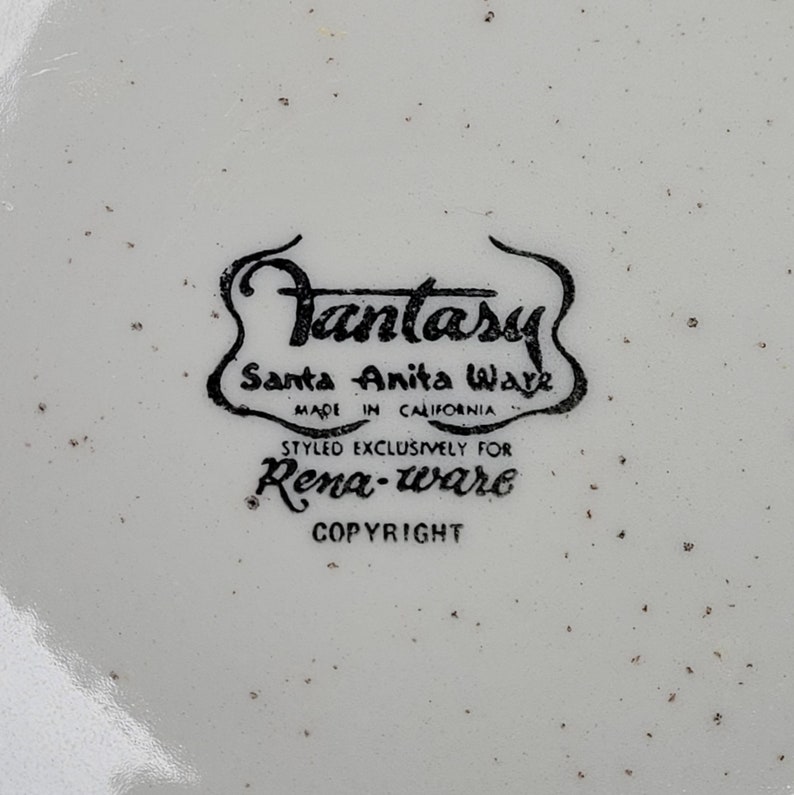 May include: Black and white logo on a white background that reads "Fantasy Santa Anita Ware Made in California Styled Exclusively for Rena-ware Copyright"