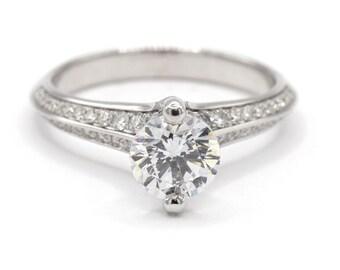 Anillo de compromiso para mujer en oro blanco de 18 quilates con circonitas cúbicas engastadas en pavé de diamantes y con borde afilado.