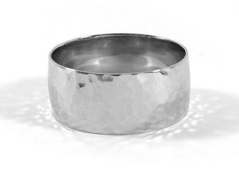 May include: A silver hammered wedding band with a rounded profile.