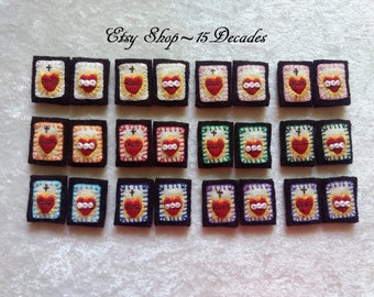 May include: A selection of small, embroidered religious patches. Each patch displays a red heart with a cross and flames, framed by a white border. The patches are set against a black backdrop. Text reads "Etsy Shop ~ 15 Decades".