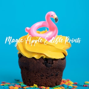 May include: A chocolate cupcake with yellow frosting, topped with a pink flamingo-shaped decoration. The cupcake sits on a blue background with colorful sprinkles. Text on the image reads "Magic Apple Edible Prints."