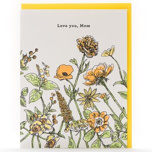 May include: A greeting card with a floral design in shades of yellow and orange. The card reads "Love you, Mom".