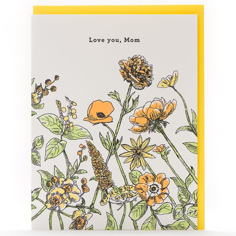 May include: A greeting card with a floral design in shades of yellow and orange. The card reads "Love you, Mom".