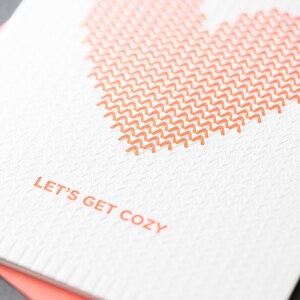 Carte typographique « Soyons douillets » en forme de coeur tricoté