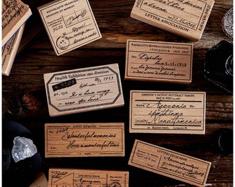 May include: A collection of vintage-style wooden stamps with various designs and text. The stamps feature handwritten text, including "Health Exhibition 1884-division", "Wonderful memories", "Letters from afar", and "Carte Postale".