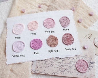 May include: Nine wax seals in various shades of pink, from light to dark, with the word "Just" written in a cursive script inside each seal. The seals are labeled with their color names: Petal, Nude, Pure Silk, Rosa, Candy Pink, Pink, Light Pink, Dusty Pink.