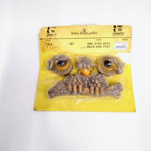 May include: A set of owl eyes, beak, and feet for crafting. The set is packaged on a yellow card with the text "Yaley Enterprises" and "Owl Eyes with Beak and Feet".