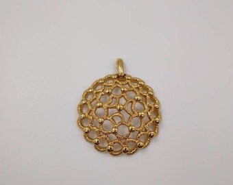 May include: A gold pendant with a circular, intricate design featuring a delicate, openwork pattern of small circles and loops.