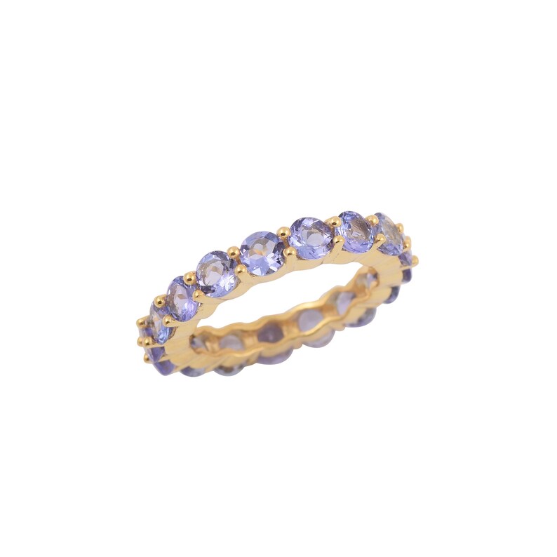 May include: A gold band ring with a row of light purple gemstones.