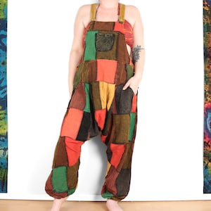 Könnte beinhalten: Patchwork-Overall in Braun-, Rot-, Grün- und Gelbtönen. Der Overall hat eine lockere, weite Passform und ist aus einem weichen, bequemen Stoff gefertigt.