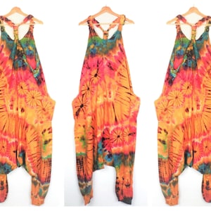 May include: A tie-dye jumpsuit with a halter top and wide legs. The jumpsuit is in shades of orange, pink, blue, and green.