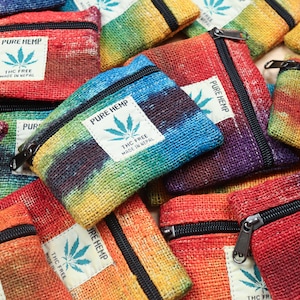 May include: A selection of small, colourful hemp pouches with black zips. Each pouch has a label that reads "PURE HEMP" and "THC FREE MADE IN NEPAL" with a cannabis leaf graphic. The pouches are in a variety of rainbow colours.