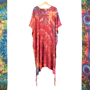 Peut inclure: Une kaftan rouge, bleue et jaune à motifs tie-dye avec des manches courtes et une coupe ample. La kaftan a un col rond et une longue jupe fluide.