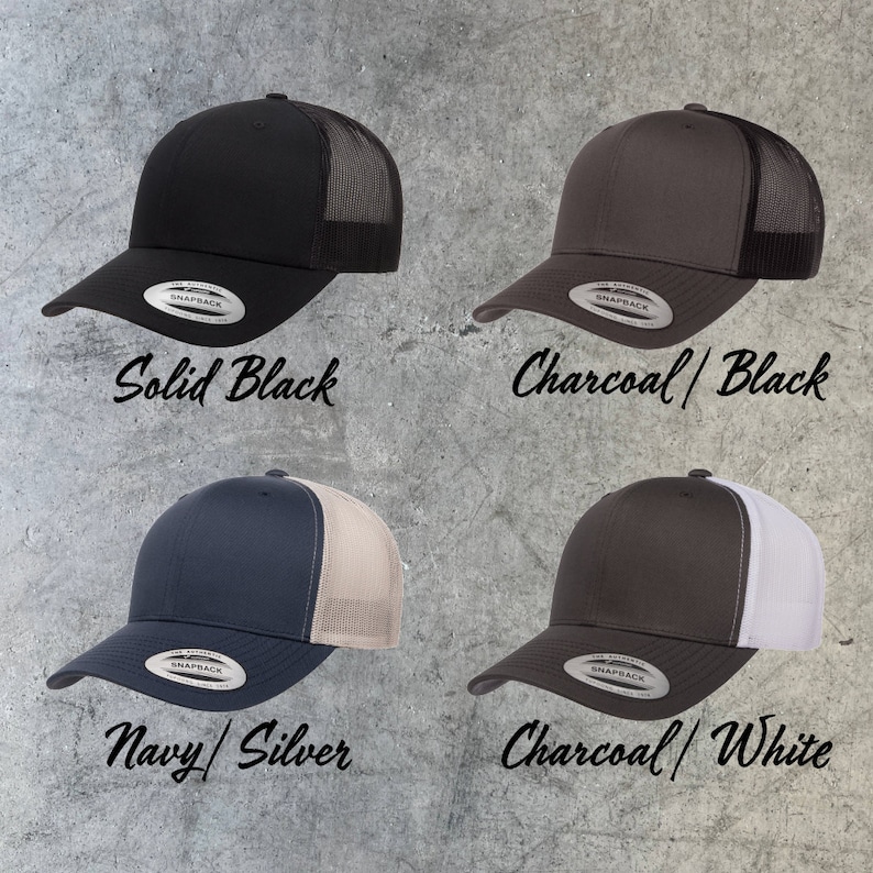 May include: Four trucker hats in different color combinations. The hats are black, charcoal with black mesh, navy with silver mesh, and charcoal with white mesh. Each hat has a Snapback closure and the word "SNAPBACK" is printed on the back of the hat.