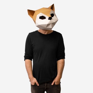 May include: A person wearing a brown and white origami-style fox mask. The mask has a geometric design and covers the person's entire head.