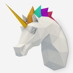 May include: A white origami unicorn head with a gold horn and a colorful mane. The mane is made of paper and is folded into a series of triangles. The colors of the mane are yellow, green, purple, and red.
