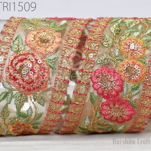 May include: Beige embroidered trim with pink, orange, and green floral designs. The trim has gold and pink accents and sequins.