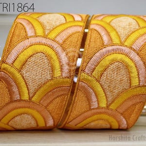 a decorative fabric with a repeating pattern of yellow and orange waves or circles, creating a visually striking and intricate design.