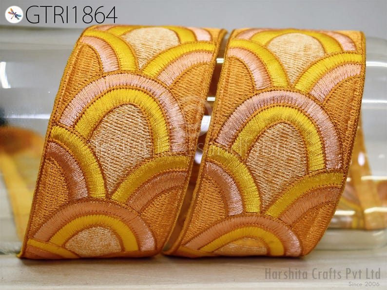 a decorative fabric with a repeating pattern of yellow and orange waves or circles, creating a visually striking and intricate design.