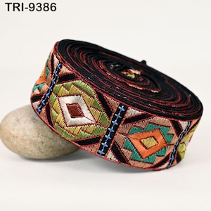 May include: A close-up of black and multi-colored trim with a geometric pattern. The trim is rolled up and has a textured surface.