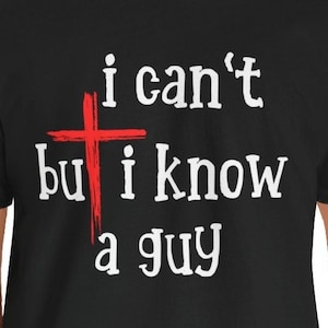 May include: Black t-shirt with white text that reads "i can't but i know a guy" with a red cross over the word "but".