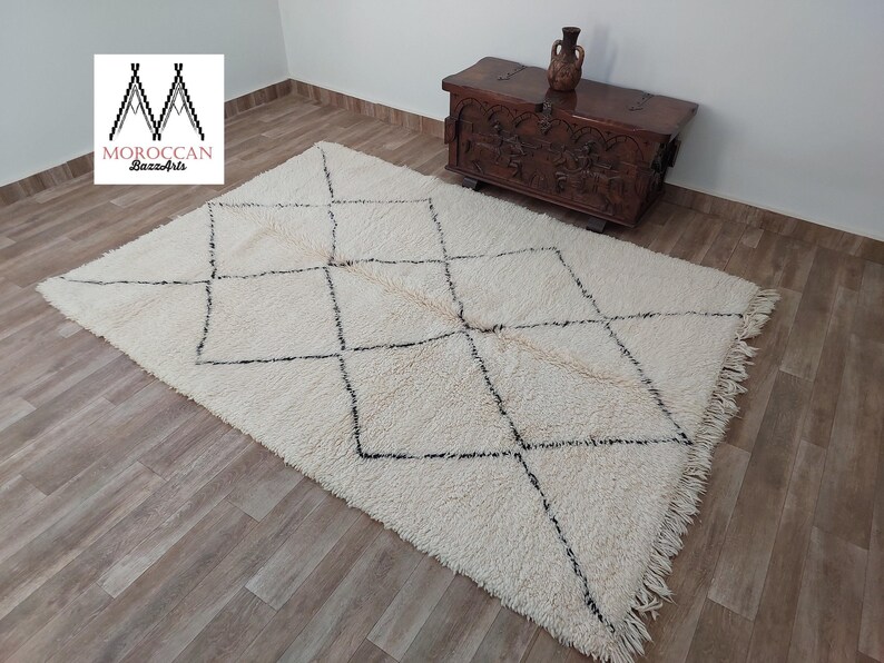 Authentic Beni Ourain Moroccan rug in cream handwoven wool with black diamond lattice, fringed edges on a 5x9 area rug.