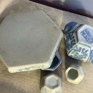 May include: A blue and white porcelain tea set with a hexagonal teapot, creamer, sugar bowl, and a hexagonal tray. The teapot has a handle and a spout. The tray has a floral design.