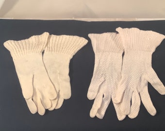 May include: Two pairs of white gloves are displayed side by side. The pair on the left features a smooth, solid knit texture with a flared cuff. The pair on the right features a vertical ribbed, crocheted texture with a flared, scalloped cuff.