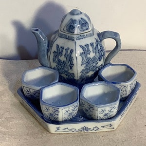 May include: A blue and white porcelain tea set with a teapot and four cups. The set features a floral design and is perfect for a traditional tea ceremony.