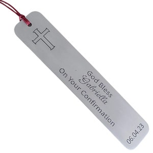 May include: Silver bookmark with a cross design and the text "God Bless Gabriella On Your Confirmation 06.04.23".