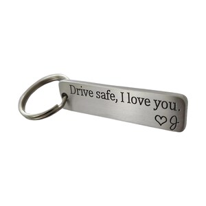 May include: Silver keychain with a rectangular tag that reads "Drive safe, I love you." with a heart symbol.