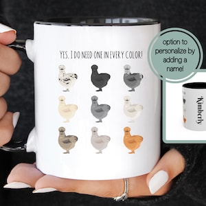May include: White ceramic mug with a black rim and handle. The mug features a graphic of nine chickens in different colors with the text "YES, I DO NEED ONE IN EVERY COLOR!"  A smaller image of a similar mug with the name "Kimberly" is shown in the upper right corner. The text "option to personalize by adding a name!" is also shown in the upper right corner.