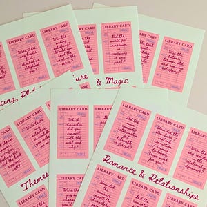 May include: A collection of pink library cards with handwritten questions on a light green background. The cards are grouped together, with titles like "Pacing, Plot" and "Romance & Relationships" in cursive.