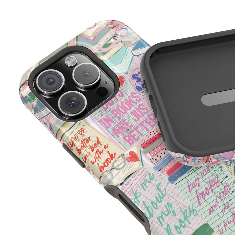 May include: A phone case with a colorful design featuring books, hearts, and glasses. The case has the text "IN BOOKS ARE JUST BETTER" and "life is better in bed with a book". The case is black and gray.
