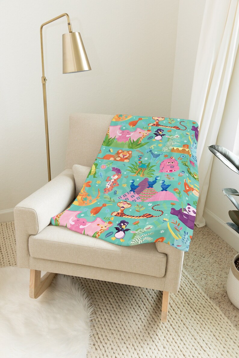 May include: A soft, plush throw blanket featuring a colorful pattern of various animals, including a tiger, penguin, and giraffe, on a turquoise background.