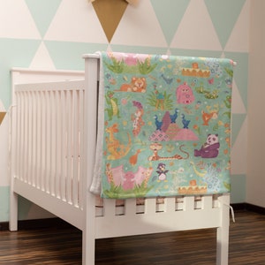 May include: A white crib with a colorful baby blanket featuring a variety of animals, including a lion, a penguin, a panda, and a giraffe. The blanket is hanging on the crib and has a light blue background with green grass and flowers.