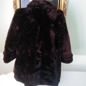 May include: A brown faux fur coat with a collar and long sleeves.