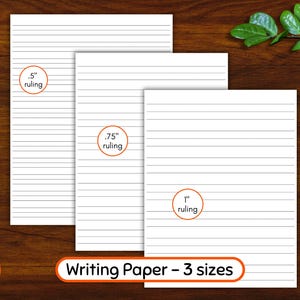 May include: Three sheets of white lined writing paper with different ruling sizes: .5", .75", and 1". The text "Writing Paper - 3 sizes" is displayed. Two pencils, blue and green, are on the wooden surface.