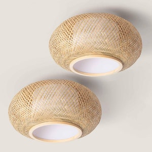 May include: Two round, woven bamboo ceiling light fixtures with white fabric shades. The lights are hanging from the ceiling.
