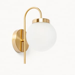 May include: A gold wall sconce with a frosted glass globe. The sconce has a curved arm and a round base.