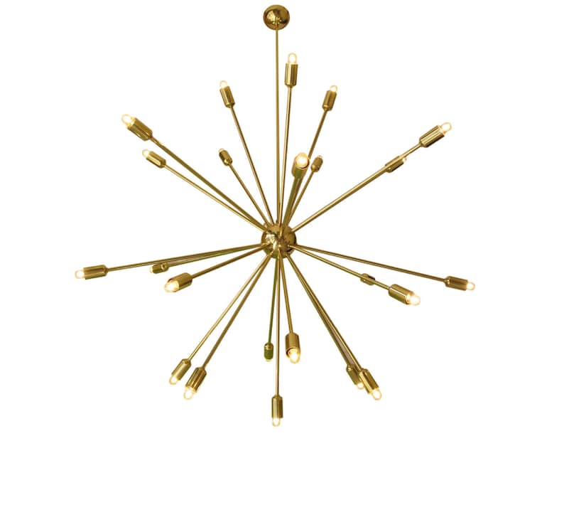 May include: A gold-toned metal chandelier with multiple arms extending outward, each ending in a light bulb. The chandelier has a starburst design.