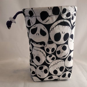 May include: A black and white drawstring bag with a repeating pattern of Jack Skellington's face from the Nightmare Before Christmas.